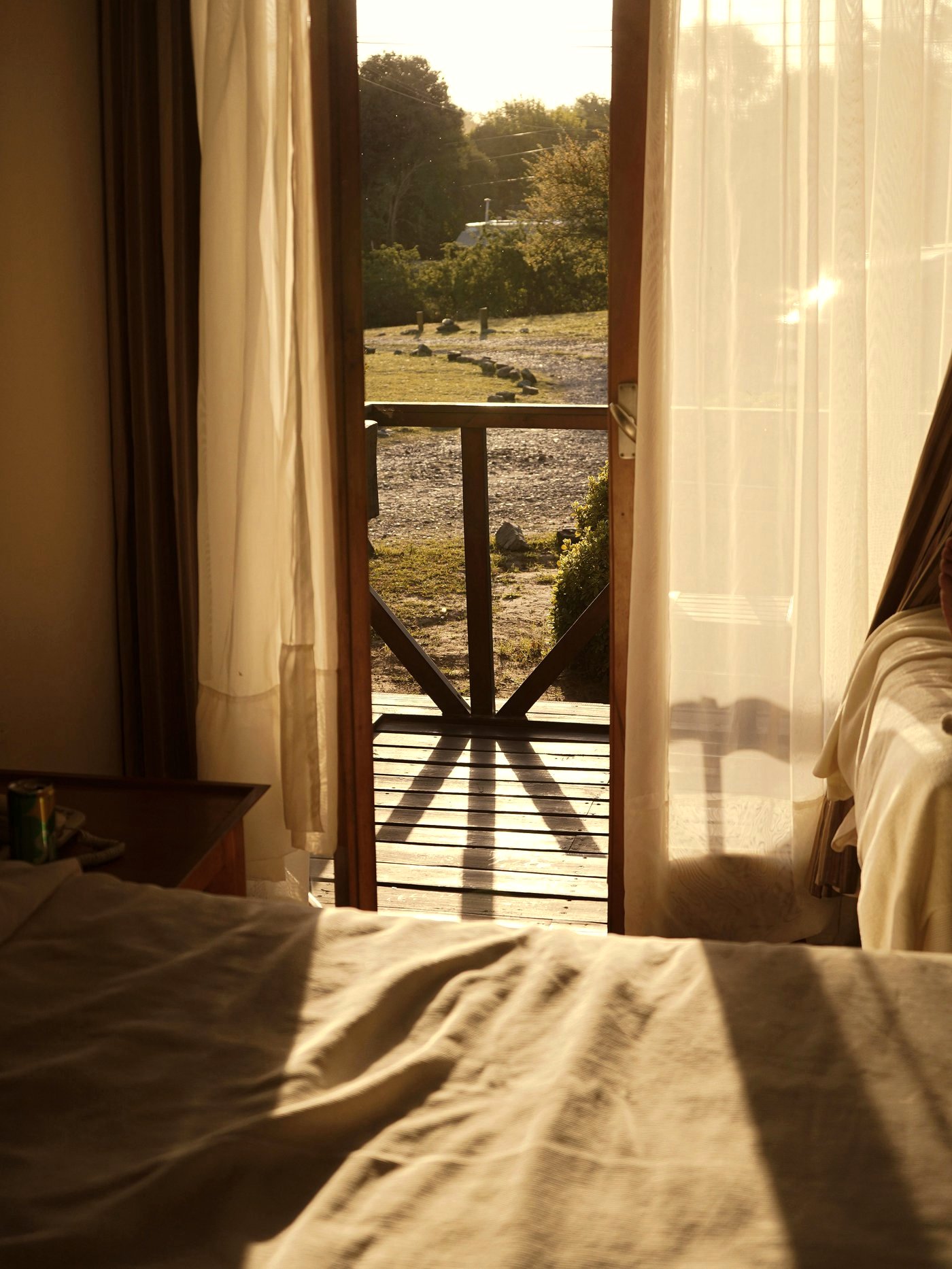 Cama y puerta abierta al amanecer dorado